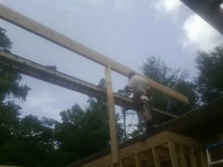 Carpenter setting a ridge beam over a new addition frame — Ice Dam Removal by Roofing Brothers in Verona